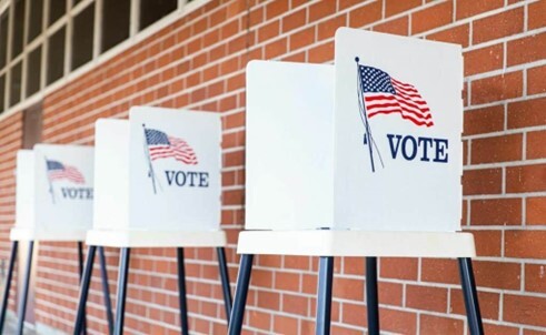 Voting stations set up against a wall.